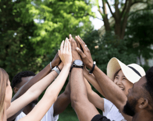 Group of people raising hands together